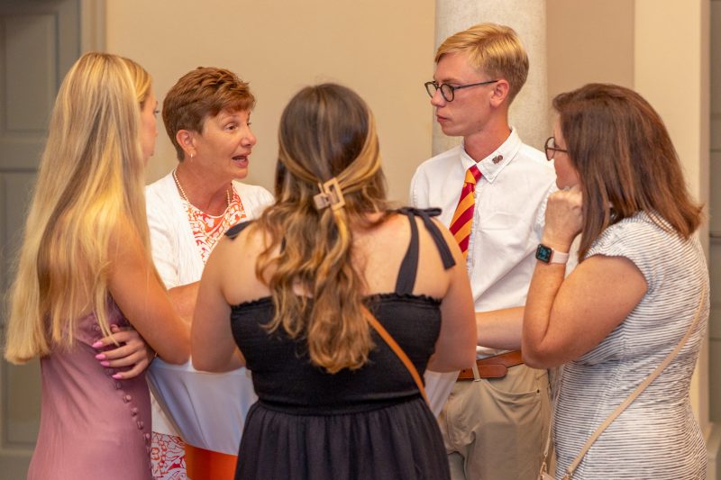 Susan Short speaking with a group of people inside the Steger Center